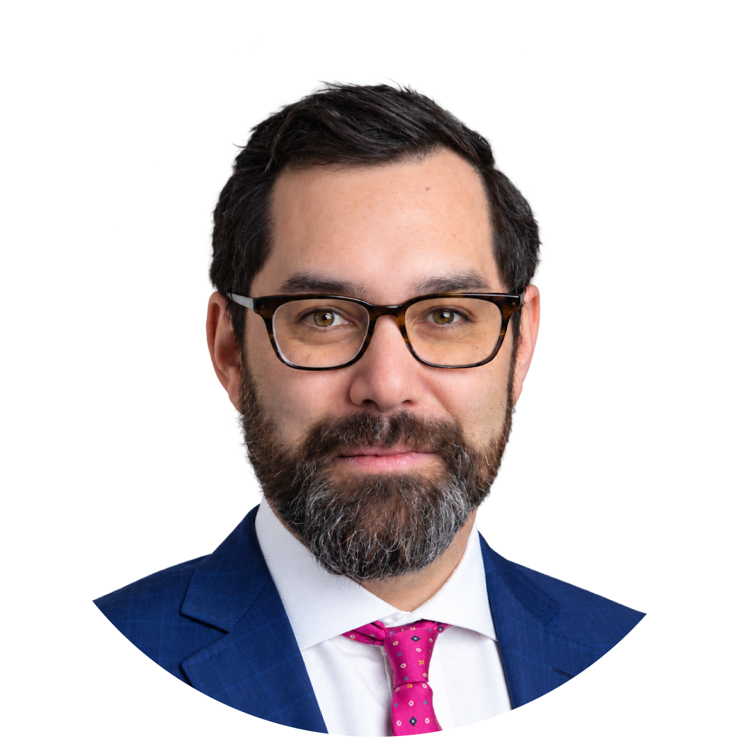 Man with dark hair and beard, wearing glasses, a blue suit, white shirt, and pink tie, facing forward against a plain white background—a professional look befitting the spirit of Novi Calgary Connect 2026.